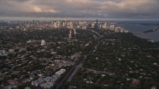 AX0022_022 - 5K stock footage aerial video tilt from Coconut Grove suburbs to reveal Downtown Miami at sunset, Florida