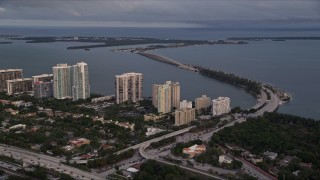 AX0022_025 - 5K aerial stock footage of waterfront condo complexes and the Rickenbacker Causeway in Downtown Miami at sunset, Florida