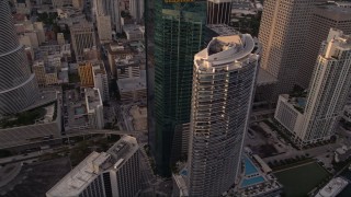 AX0022_030E - 5K aerial stock footage fly over modern high-rise to approach Epic Hotel and Wells Fargo Center in Downtown Miami at sunset, Florida