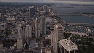 AX0022_032 - 5K aerial stock footage tilt to reveal and approach skyscrapers in Downtown Miami at sunset, Florida