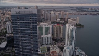 AX0022_043 - 5K aerial stock footage orbit top of Four Seasons Hotel to reveal waterfront skyscrapers in Downtown Miami at sunset, Florida