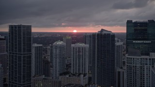 AX0022_085E - 5K aerial stock footage of setting sun behind tall skyscrapers in Downtown Miami, Florida
