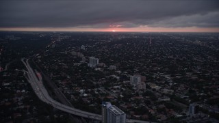 AX0022_093 - 5K aerial stock footage of Coral Way suburban neighborhoods with setting sun on horizon in Florida