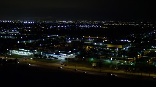 AX0023_002 - 5K aerial stock footage approach shops and gas stations at night in Kendall, Florida
