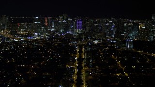 AX0023_003E - 5K aerial stock footage tilt from SW 3rd Ave to reveal colorful Downtown Miami skyline at night, Florida