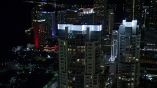 AX0023_025E - 5K aerial stock footage of illuminated rooftops of Vizcayne towers at Night in Downtown Miami, Florida