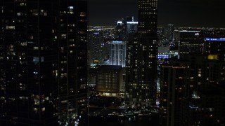 AX0023_037E - 5K aerial stock footage tilt from bridge to reveal and approach skyscrapers in Downtown Miami at night, Florida