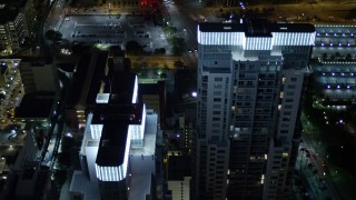 AX0023_039E - 5K aerial stock footage approach twin skyscrapers at night in Downtown Miami, Florida