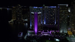AX0023_045E - 5K stock footage aerial video tilt from Bayside Marketplace to reveal InterContinental in Downtown Miami at night, Florida