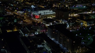 AX0023_070 - 5K aerial stock footage of cafes and shops on an intersection at night in South Beach, Florida