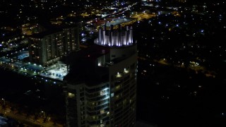 AX0023_093E - 5K aerial stock footage tilt to the Fontainebleau Miami Beach Resort rooftop at night, Florida