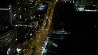 AX0023_095E - 5K aerial stock footage of yacht docked by Collins Avenue at night in  Miami Beach, Florida