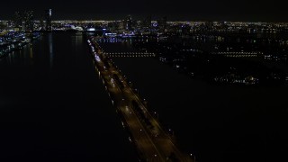 AX0023_127E - 5K aerial stock footage of approaching the MacArthur Causeway with light traffic at night in Miami, Florida