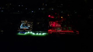 AX0023_131E - 5K aerial stock footage flyby 5 Star Island Hotel with bright lights at nighttime in Florida
