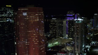 AX0023_145E - 5K stock footage aerial video of passing Miami Tower with orange lighting at night in Downtown Miami, Florida