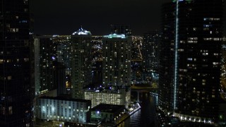 AX0023_155E - 5K aerial stock footage fly over Miami River past skyscrapers at night in Downtown Miami, Florida