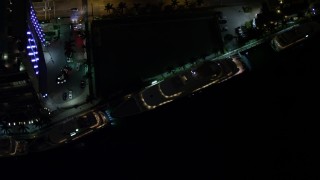 AX0023_173E - 5K aerial stock footage bird's eye orbit of a yacht on the Miami River at night in Downtown Miami, Florida