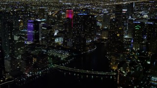 AX0023_178E - 5K aerial stock footage of Brickell Key Drive Bridge and skyscrapers at night in Downtown Miami, Florida