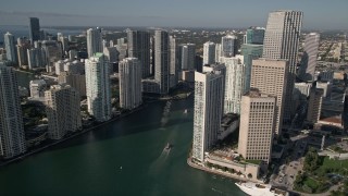 AX0024_041E - 5K aerial stock footage of flying by coastal skyscrapers and reveal Miami River, Downtown Miami, Florida