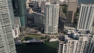 AX0024_056E - 5K aerial stock footage fly over Brickell Key Drive bridge, tilt to bird's eye of yachts on the Miami River, Downtown Miami, Florida