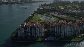 AX0024_101 - 5K aerial stock footage of orbiting condominiums on the shore, Fisher Island, Florida