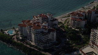 AX0024_103 - 5K aerial stock footage of orbiting oceanfront condominiums, Fisher Island, Florida