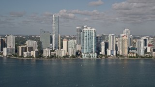 AX0024_119 - 5K aerial stock footage of flying by Downtown Miami skyline, seen from Biscayne Bay, Florida