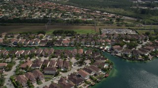 AX0025_002 - 5K aerial stock footage of flying by canal side homes in Three Lakes, Miami, Florida