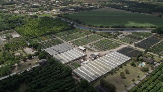 AX0025_006 - 5K aerial stock footage of flying by farmland and greenhouses, South Miami Heights, Florida