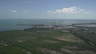 AX0025_020 - 5K aerial stock footage of flying by power lines, revealing Turkey Point Power Plant, Homestead, Florida