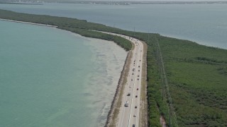 AX0025_048 - 5K aerial stock footage video of traffic on Overseas Highway, reveal coastal mangroves, Key Largo, Florida