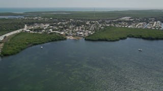 AX0025_055 - 5K aerial stock footage of flying over Lake Surprise toward neighborhood, Key Largo, Florida