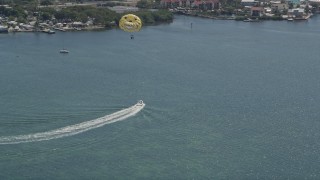 AX0025_061 - 5K aerial stock footage of speedboat pulling parasailers on Blackwater Sound, Key Largo, Florida