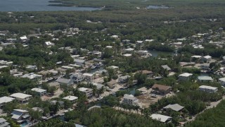 AX0025_062 - 5K aerial stock footage of flying by homes on canals, Key Largo, Florida