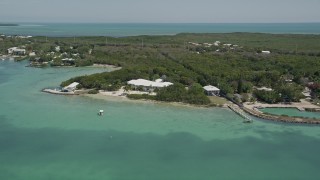AX0025_085 - 5K aerial stock footage of flying by a home on the shore, Tavernier, Florida