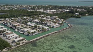 AX0025_087 - 5K aerial stock footage of flying by waterfront homes on the shore, Tavernier, Florida