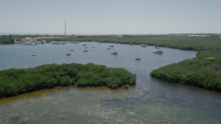 AX0025_088E - 5K aerial stock footage of flying by sailboats and fishing boats off the shore, Tavernier, Florida