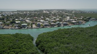 AX0025_090 - 5K aerial stock footage of flying low over mangroves toward Tavernier Creek homes, Tavernier, Florida