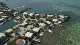 AX0025_092 - 5K aerial stock footage of panning across homes along the shore, tilt down, Tavernier, Florida