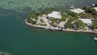 AX0025_093 - Aerial stock footage of 5K aerial  video of flying away from upscale home on the shore, Tavernier, Florida
