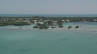 AX0025_099 - 5K aerial stock footage of approaching homes on the shore, Tavernier, Florida