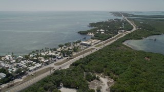 AX0025_106E - 5K aerial stock footage of following Overseas Highway, passing resorts and marinas, Islamorada, Florida