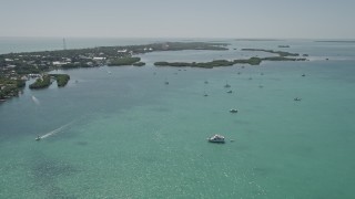 AX0025_112 - 5K aerial stock footage of flying over fishing boats and sailboats near the shore, Islamorada, Florida