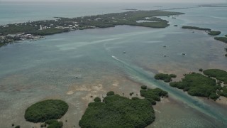 AX0025_114 - 5K aerial stock footage of flying over mangroves, approaching fishing boats off shore, Islamorada, Florida