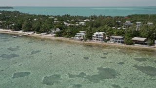 AX0025_125 - 5K aerial stock footage of oceanfront homes on the coast in Islamorada, Florida