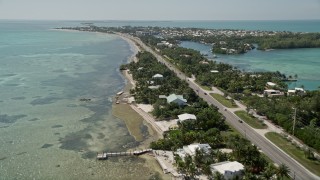 AX0025_128 - 5K aerial stock footage of flying by homes along the coast, Overseas Highway, Islamorada, Florida