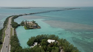 AX0025_133 - 5K aerial stock footage tilt from water to reveal Overseas Highway and Craig Key, Florida