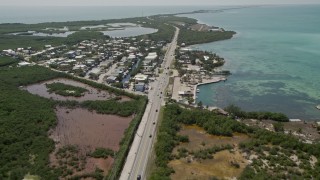 AX0025_139E - 5K aerial stock footage of panning across Overseas Highway, revealing neighborhood, Layton, Florida