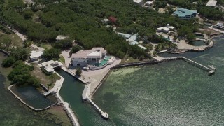 AX0025_156 - 5K stock footage aerial video of flying by a large home on shore of Grassy Key, Marathon, Florida
