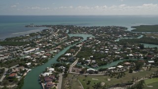AX0026_009 - 5K aerial stock footage of flying by homes and canals along coast, Marathon, Florida